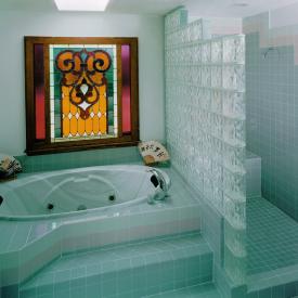 A curtain of glass bathes the room in soft light while dividing private areas.  